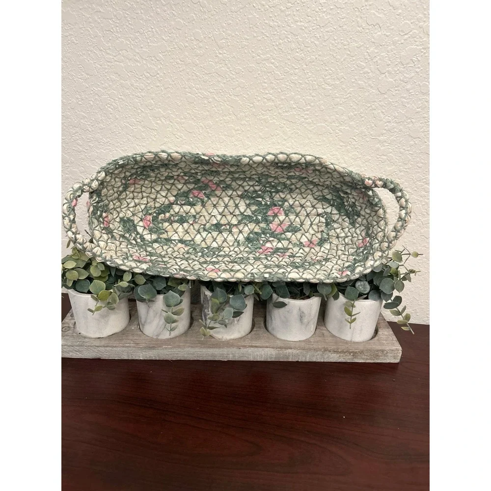 vintage oval rag rug basket features a braided, quilted design in green and pink